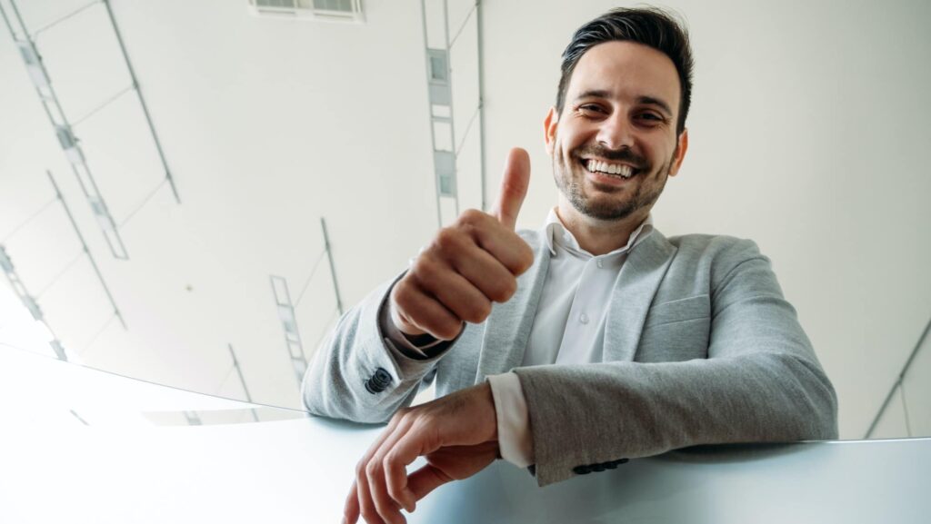 Happy business man shows thumb up sign gesture